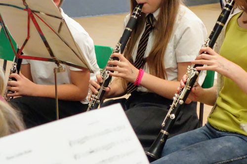 Two young people and a teacher playing clarinet
